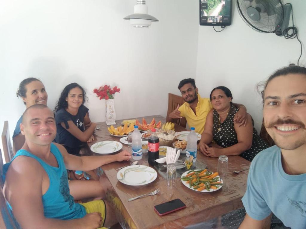 un grupo de personas sentadas alrededor de una mesa en Villa Arshu., en Bentota