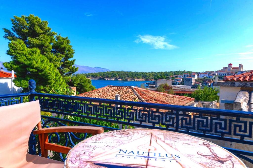 a table on a balcony with a view of a city at Nautilus Luxury Suites in Galaxidi