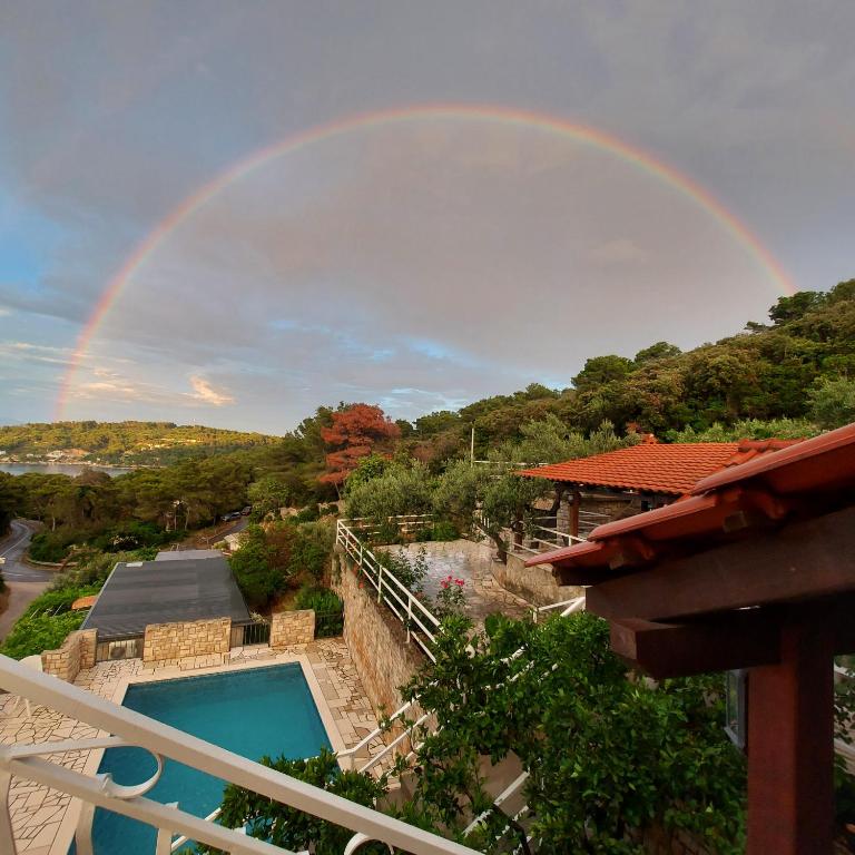 a rainbow over a house with a swimming pool at Villa Šolta in Rogač