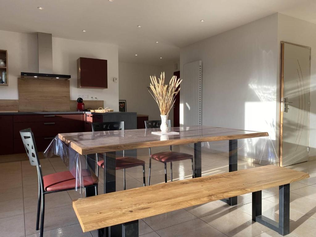 a dining room with a wooden table and chairs at 1100-Maison au cœur du village de Planguenoual. in Planguenoual