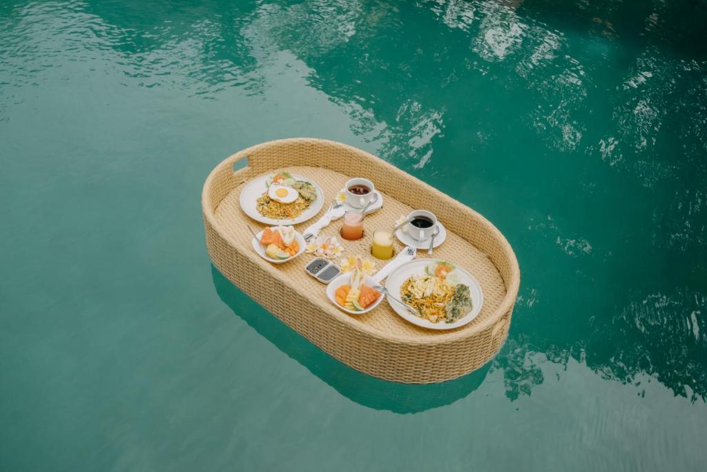 a small boat with food on it in the water at Wana Karsa The Villas Ubud in Ubud