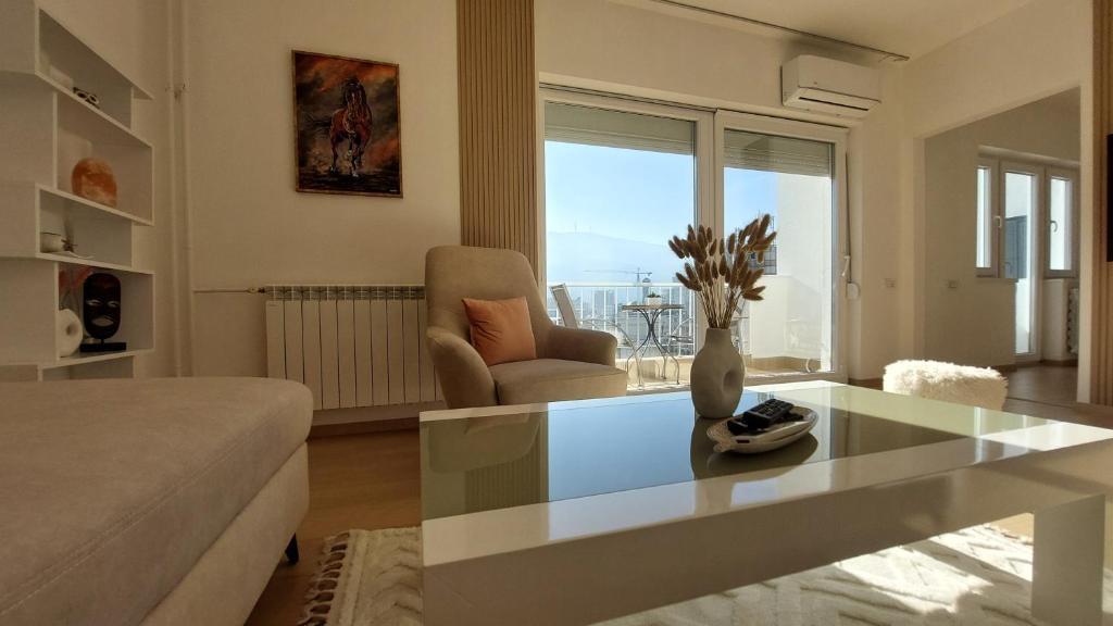 a living room with a glass table and a couch at MINA modern & cozy apartment main city square GTC Skopje in Skopje