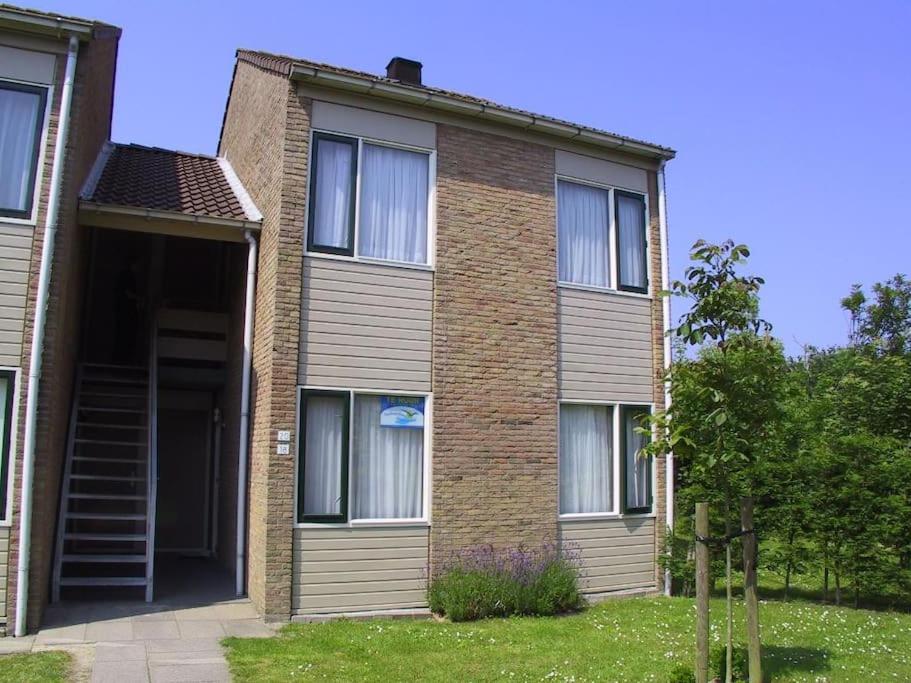 een stenen huis met een trap ervoor bij Schorrebloem 20* in Nieuwvliet