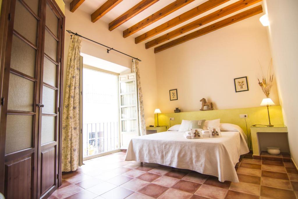 um quarto com uma cama e uma grande janela em La Casa de Las Titas em Vélez-Málaga