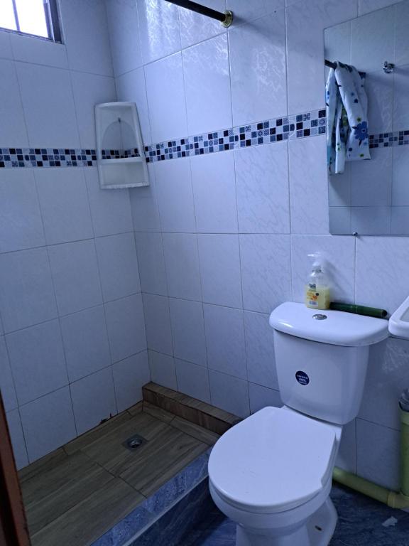 een badkamer met een wit toilet in een kamer bij El rincón de blanquita in Cali