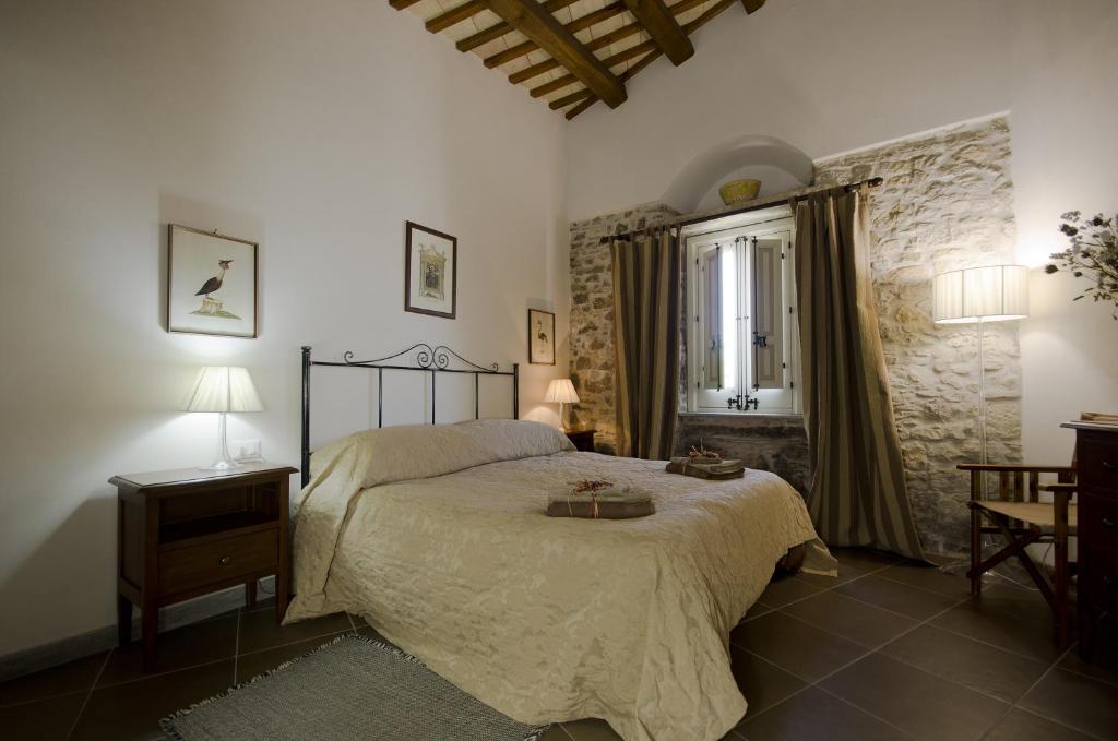 - une chambre avec un grand lit et une fenêtre dans l'établissement Residence Erice Pietre Antiche, à Erice