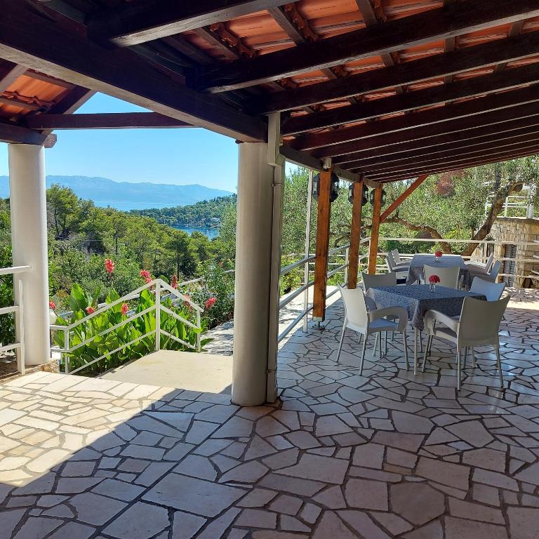 a patio with a table and chairs under a pergola at Villa Šolta in Rogač