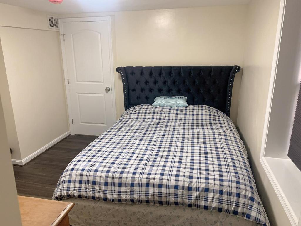 a bed with a checkered blanket in a room at Brand new en-suite private bath next Camden yard , convention center in Baltimore