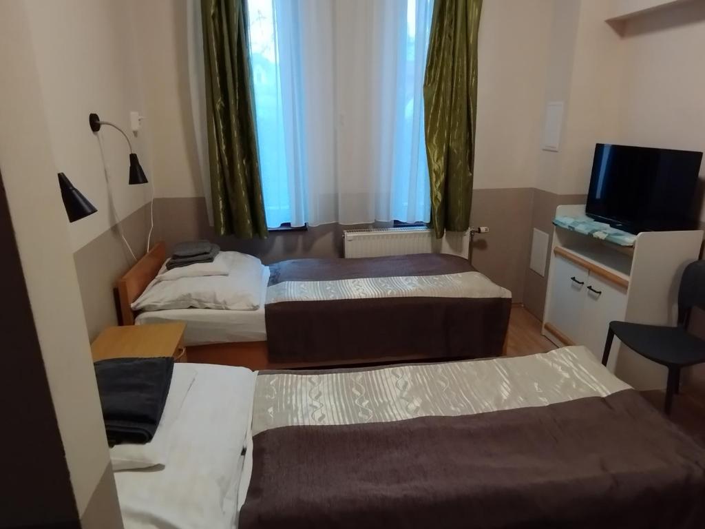 Posteľ alebo postele v izbe v ubytovaní Gyarmati Panzió & Étterem