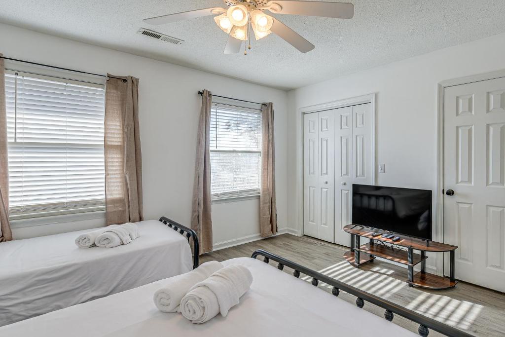 默特尔比奇1 Mi to Beach Pet-Friendly Grand Strand Townhome的一间卧室，配有两张床和一台平板电视