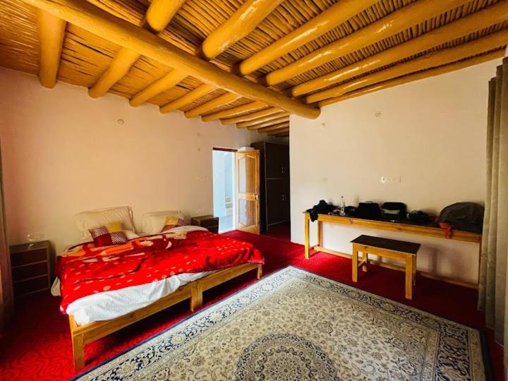zoz Aryan Valley في Dah: غرفة نوم بسرير احمر وسجادة حمراء
