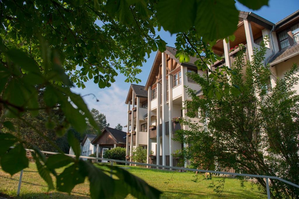 vistas a un edificio con patio de césped en Hotel Sonneck, en Knüllwald