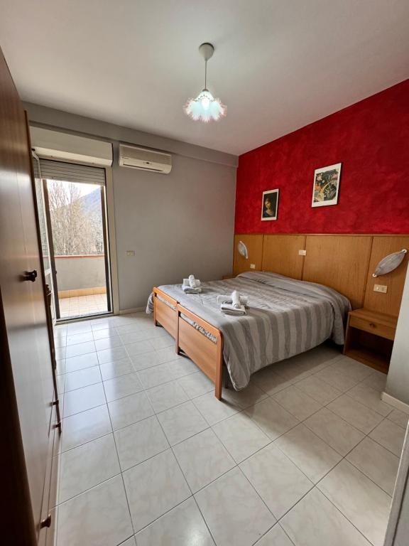1 dormitorio con cama y pared roja en Da Bosio, en Genga