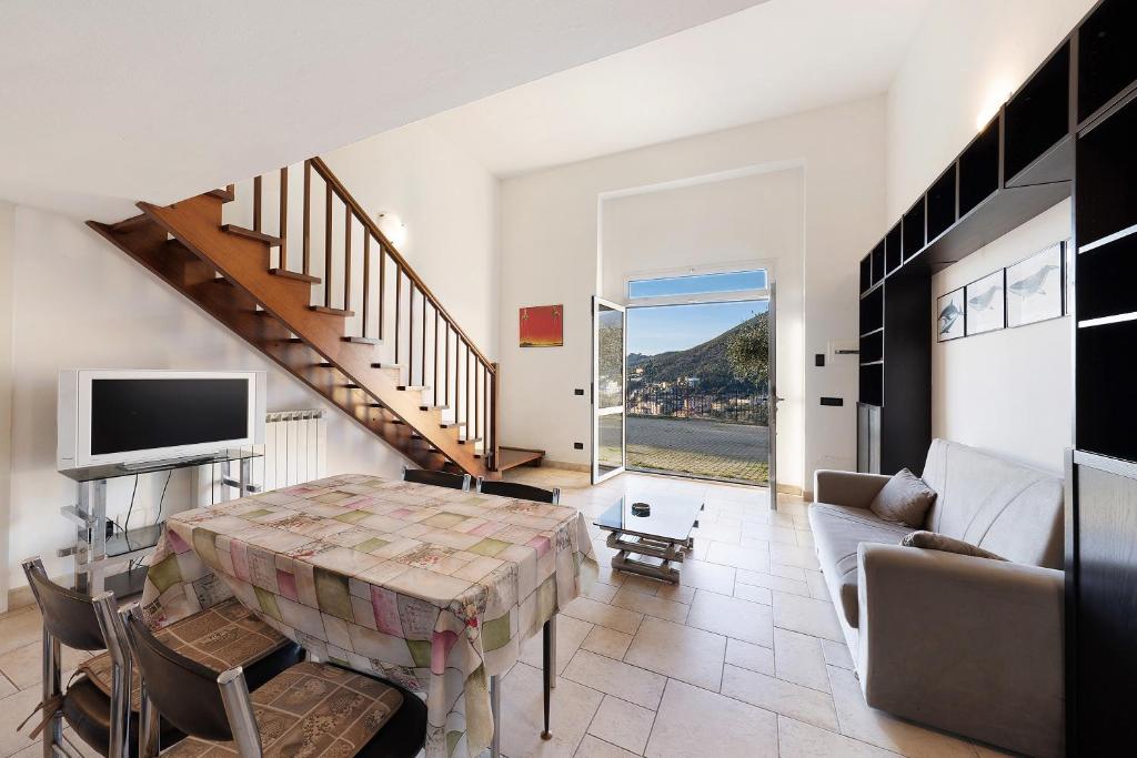 a living room with a table and a couch and stairs at Casa Max in Levanto