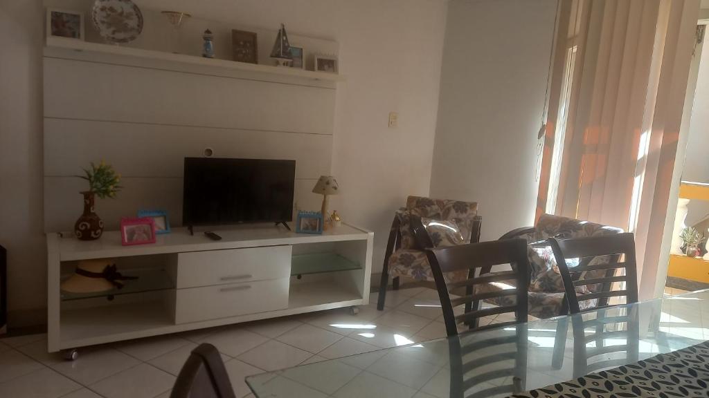 uma sala de estar com televisão num armário branco em Quarto para temporada na praia do corsário em Salvador