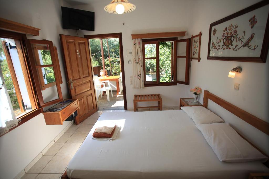 a bedroom with a large bed in a room with windows at Zoe's Place in Ios Chora