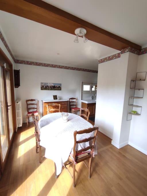 une salle à manger avec une table et des chaises blanches dans l'établissement Appartement f3 en maison calme, à Amancy