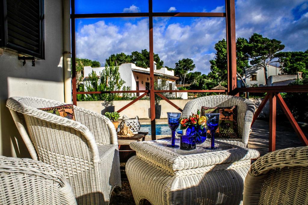 um pátio com cadeiras de vime e uma mesa com flores em Villa Buena Vista em Cala Pi