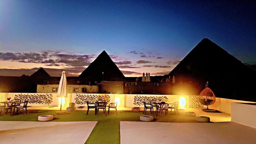 a patio with tables and chairs in front of a building at Solima pyramids inn in Cairo