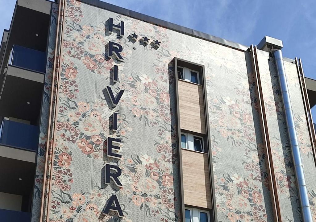 a building with a sign on the side of it at Hotel Riviera B&B in Misano Adriatico