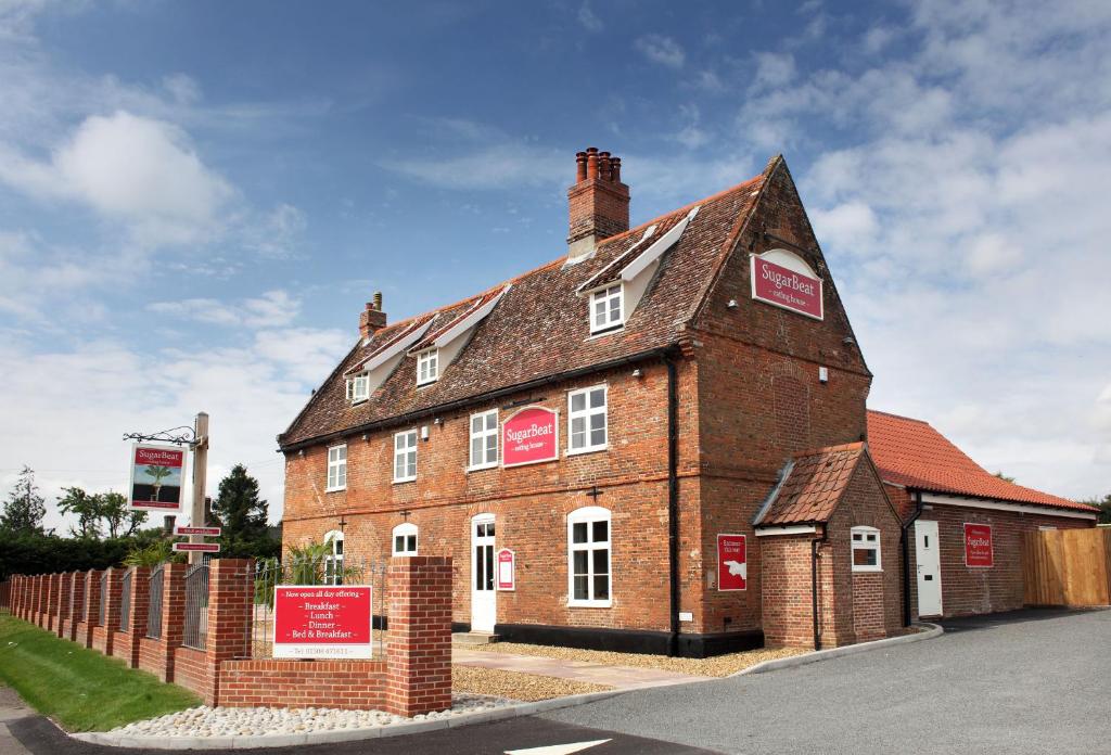 a large red brick building with signs on it at Sugarbeat Eating House in Norwich