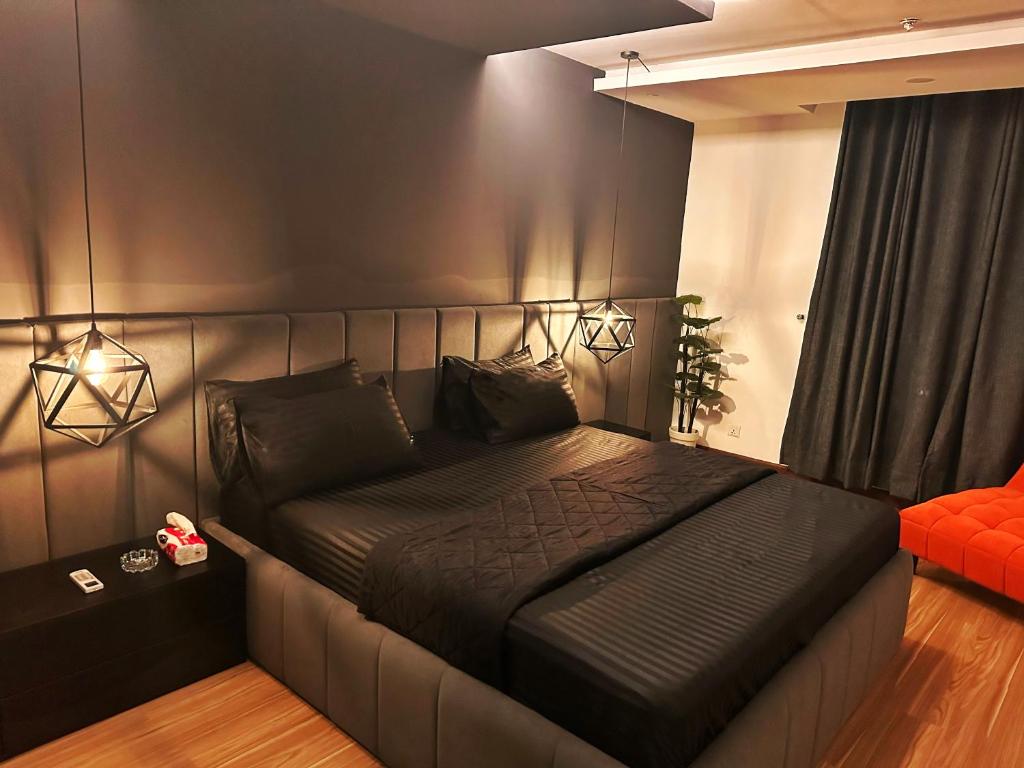 Two bedroom suite, Gold crest Mall في لاهور: غرفة نوم مع سرير مع اللوح الأمامي الأسود