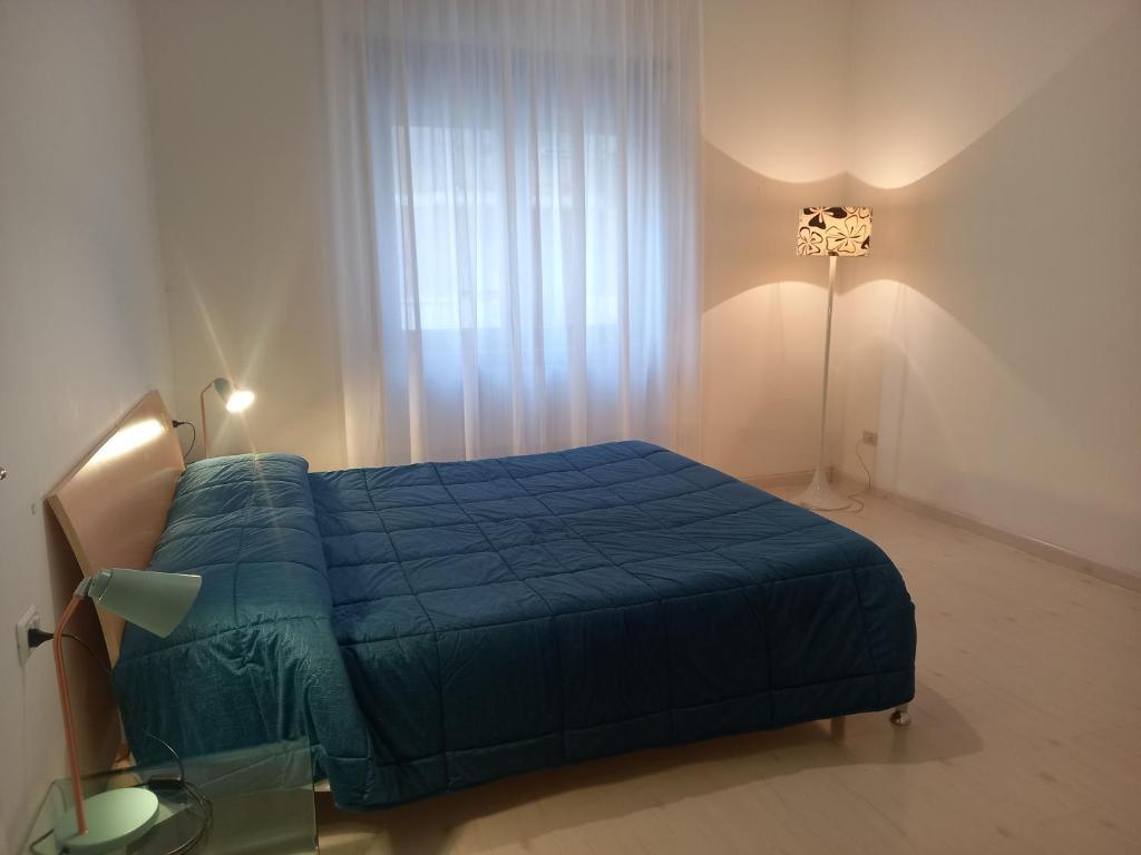 een slaapkamer met een blauw bed en een raam bij Ponte di Cecco appartamenti in Ascoli Piceno