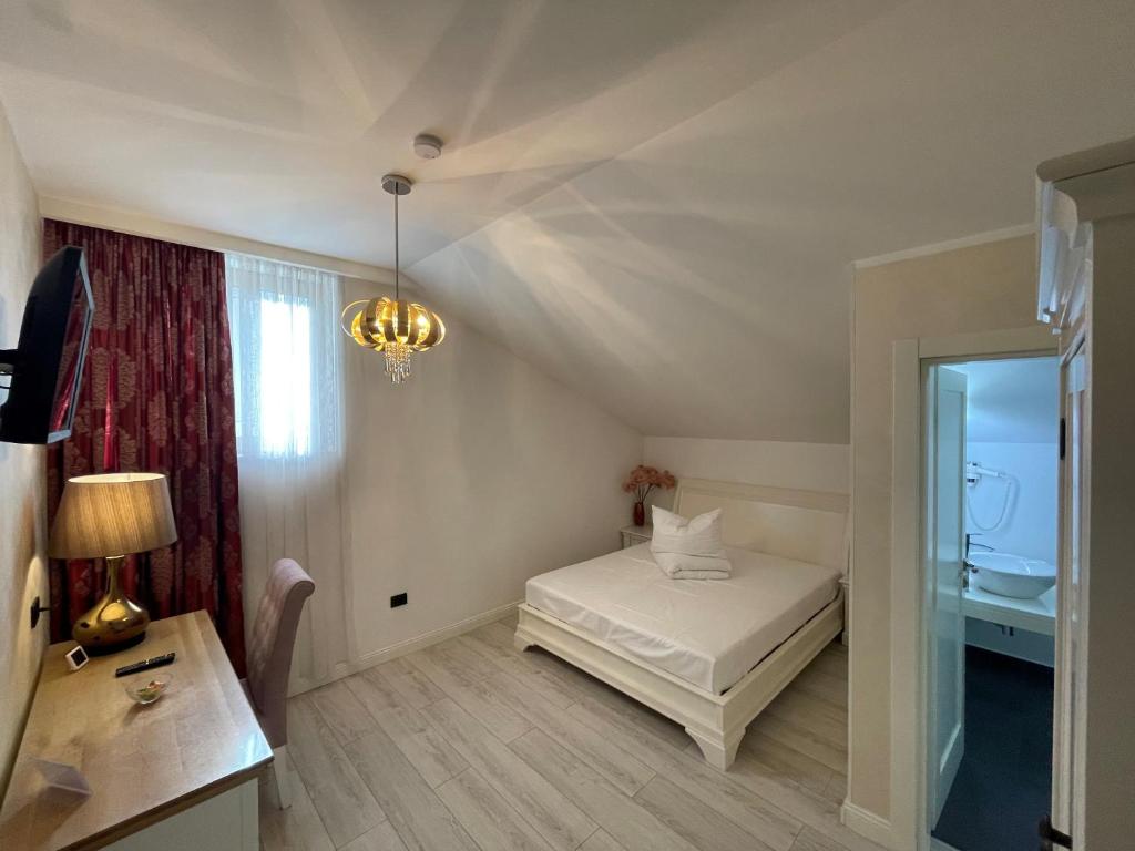 um quarto com uma cama, uma secretária e um candeeiro em Casa Del Sole em Alba Iulia