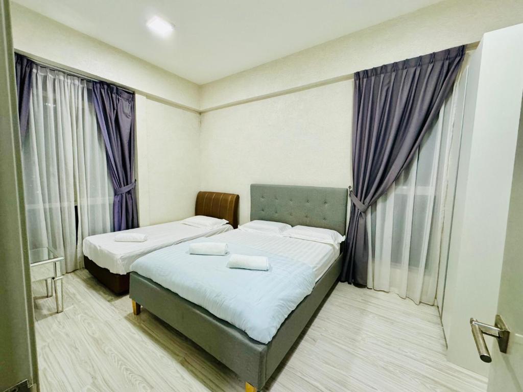 duas camas num pequeno quarto com cortinas roxas em Hstay Sutera Avenue 2Bedroom by Aida em Kota Kinabalu