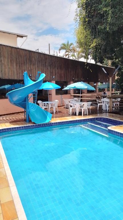 a swimming pool with a slide in a resort at Pousada Recanto Passarela in Aparecida