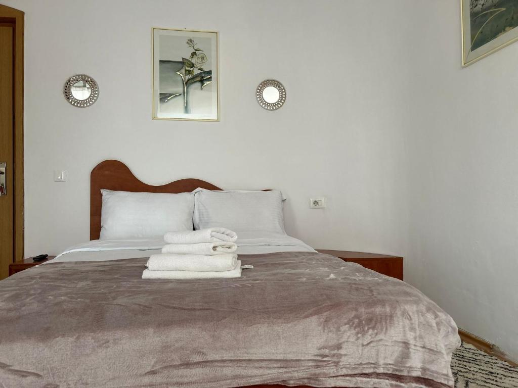 a bedroom with a bed with towels on it at Ambra Room's in Braşov