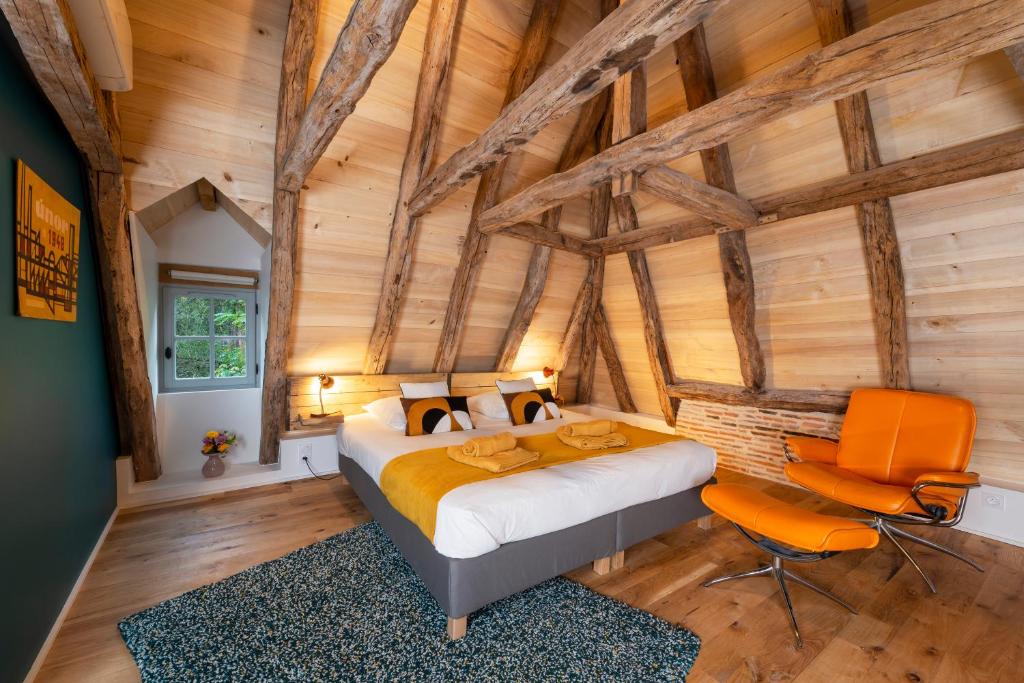 1 dormitorio con 1 cama en una habitación con paredes de madera en La maison de Ganil en Saint-Cirq-Lapopie
