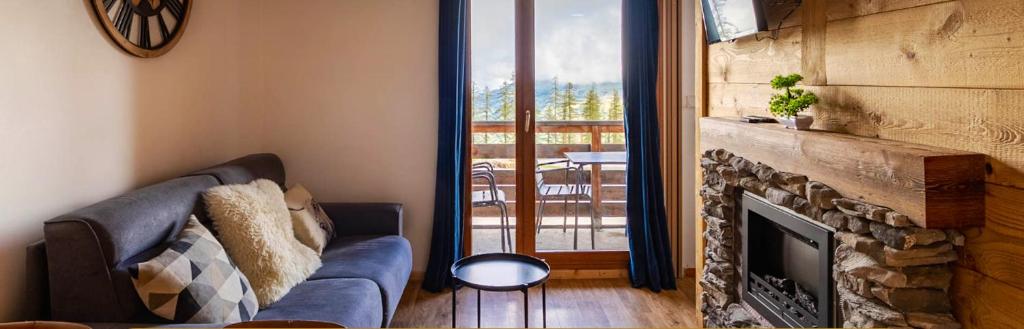 a living room with a couch and a fireplace at Appartement de 2 chambres avec piscine partagee et balcon amenage a Les Orres in Les Orres