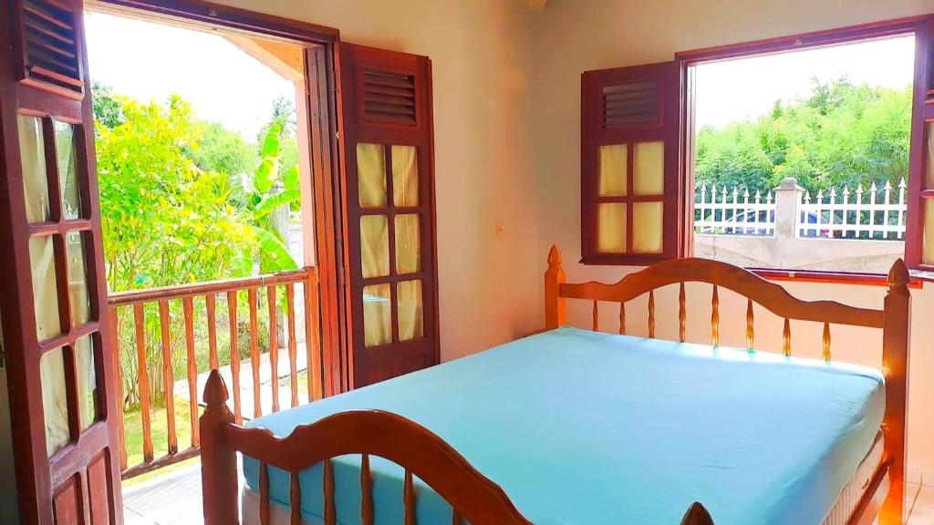 a bedroom with a bed and two large windows at Maison de 3 chambres avec jardin clos et wifi a Anse Bertrand in Anse-Bertrand