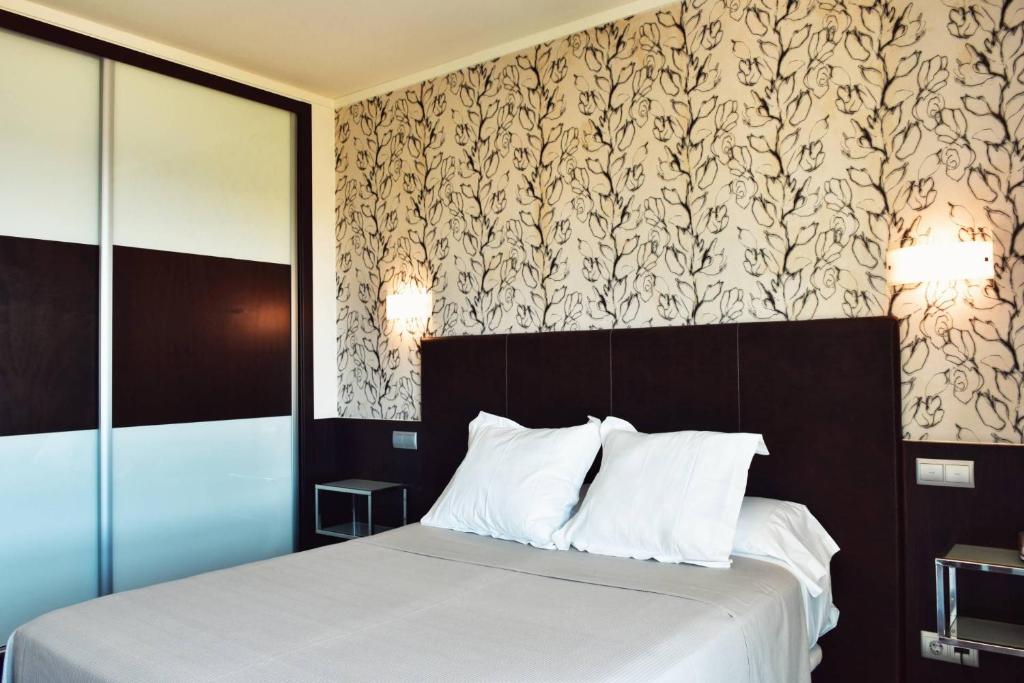A bed or beds in a room at Hotel Alda Carril