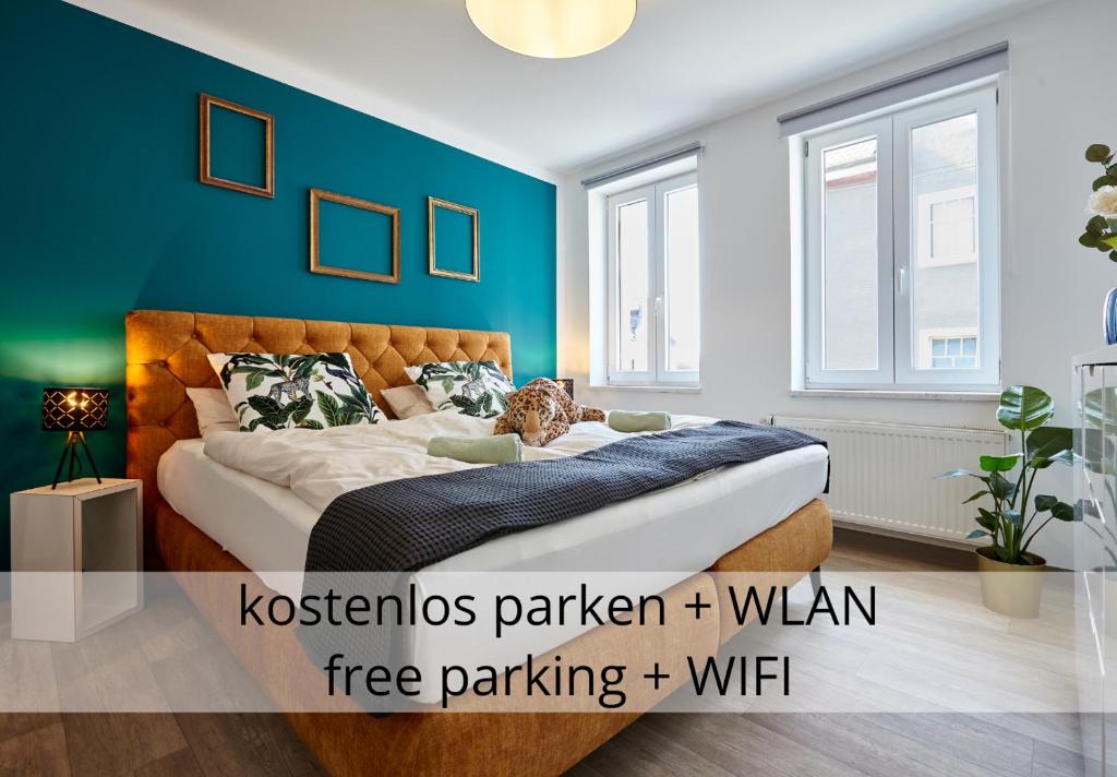 - une chambre dotée d'un lit avec un mur bleu dans l'établissement nice2be Apartments, à Augsbourg