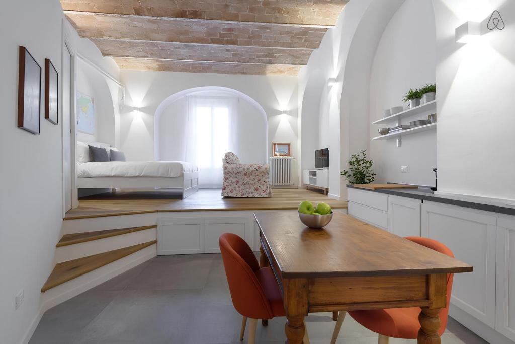 a kitchen and living room with a wooden table and chairs at FAMM Apartments - Charming open space in Trastevere in Rome