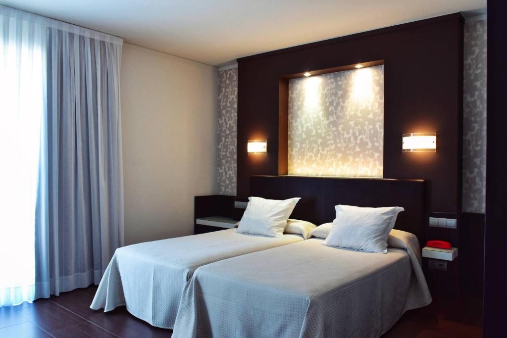 A bed or beds in a room at Hotel Alda Carril