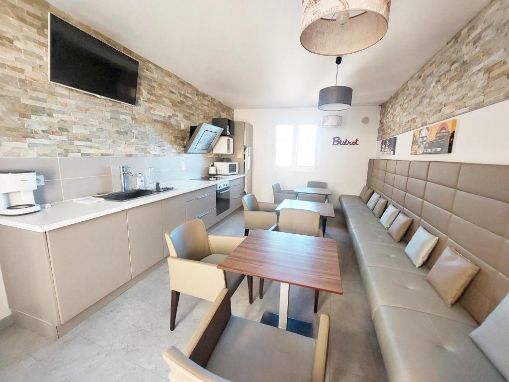 Le MasにあるGîte Bistrotのテーブルと椅子、キッチン付きのレストラン