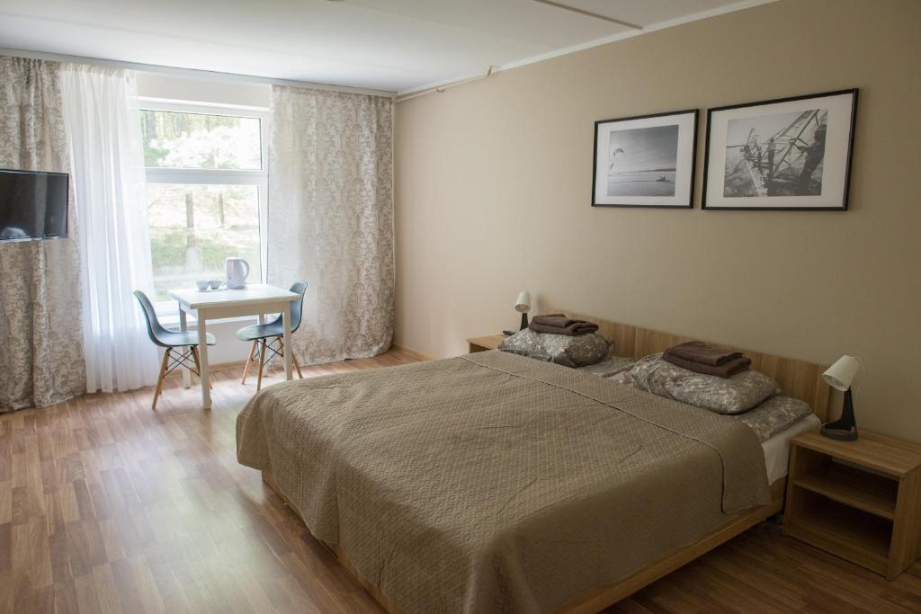 1 dormitorio con cama, mesa y ventana en Baltosios Bures, en Kaunas
