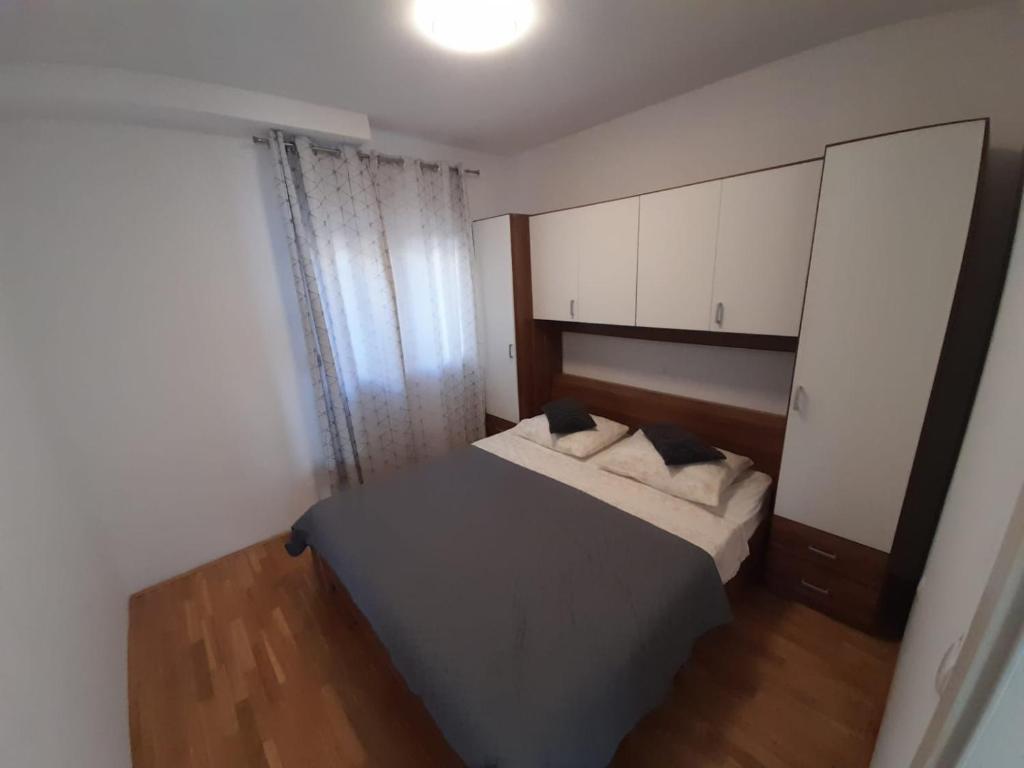 een kleine slaapkamer met een bed en een spiegel bij Pere Apartment in Omiš