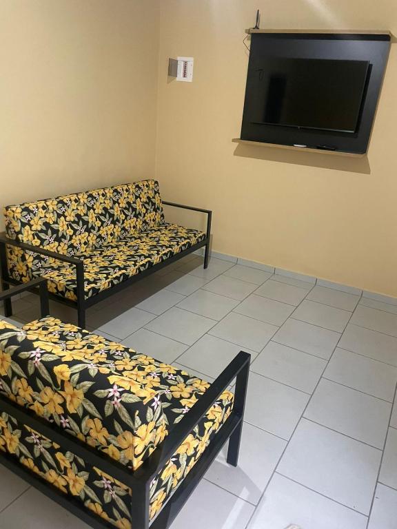 a room with two couches and a flat screen tv at Ap completo ótimo local próximo shopping 1 in Campo Grande