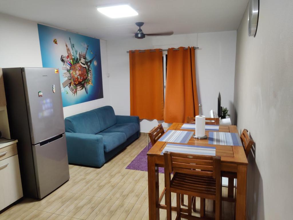 - un salon avec une table et un canapé bleu dans l'établissement F2 PARC TRINITE, à Saint-Denis