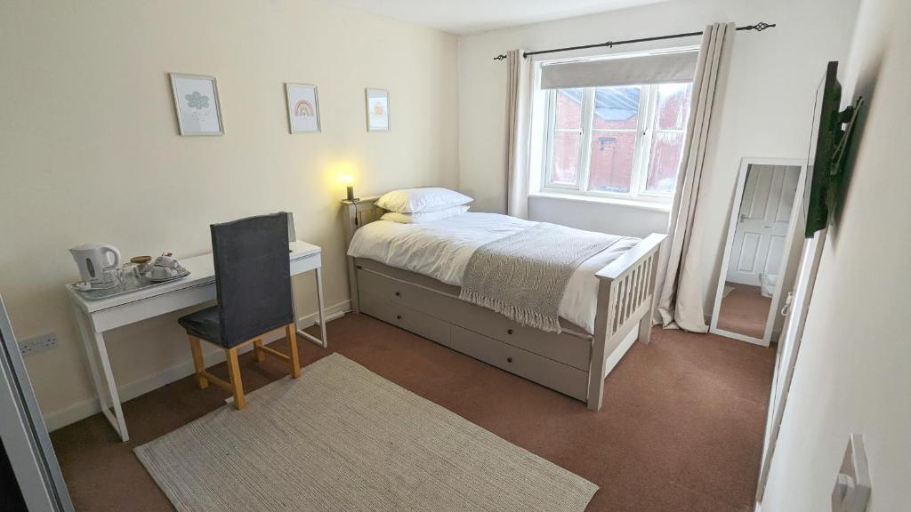 a bedroom with a bed and a desk and a window at Spacious Room with Parking TV Wi-Fi Desk Kettle in Long Eaton