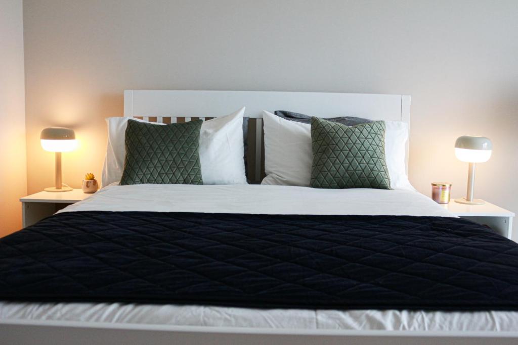a large bed with a black comforter and two lamps at Luxury Ensuite Room - With Full Privacy as only room on the top floor! in Dublin