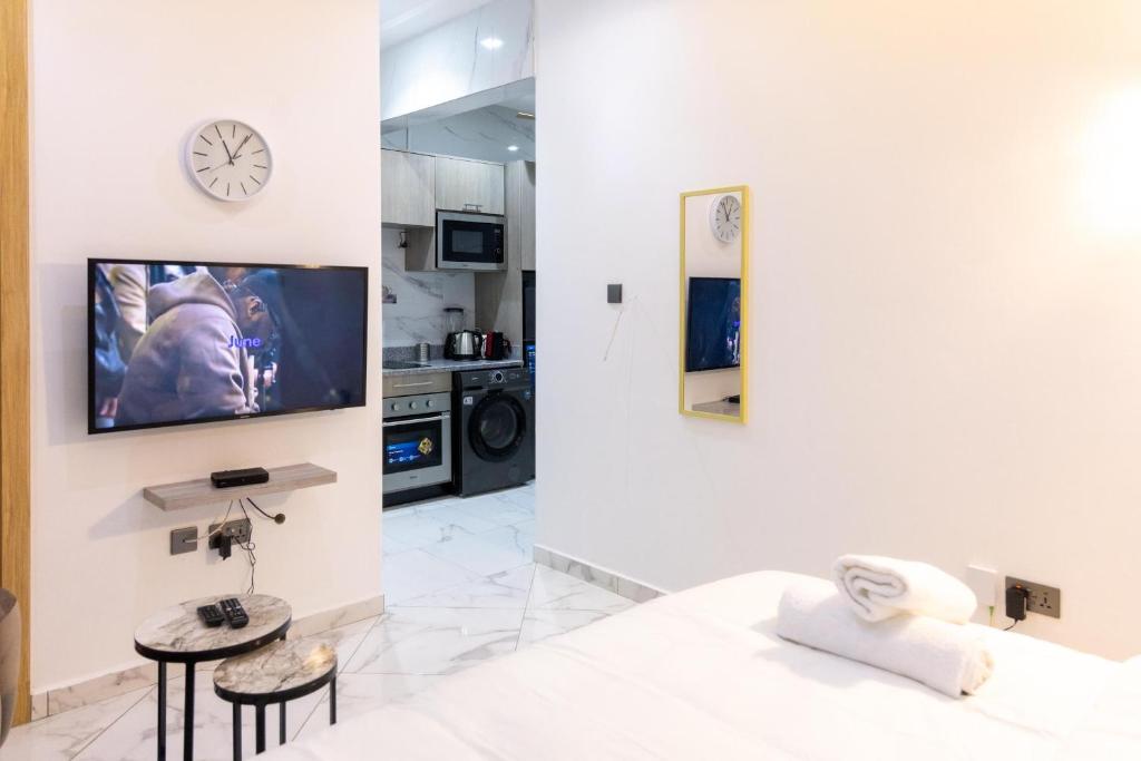 Una sala de estar con una cama y un televisor en una pared. en Classy Studio Apartment, East Airport, en Accra
