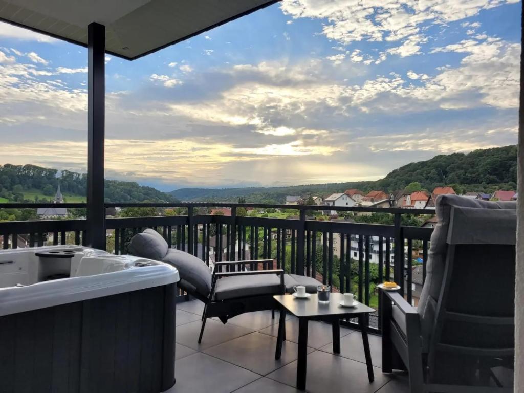 a balcony with a tub and chairs and a view at Egge Resort 7c mit Whirpool u Sauna in Altenbeken