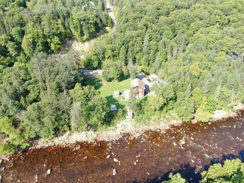 uma vista aérea de uma casa no meio de uma floresta em Domaine de la rivière Montmorency, chalet luxueux em Sainte Brigitte de Laval