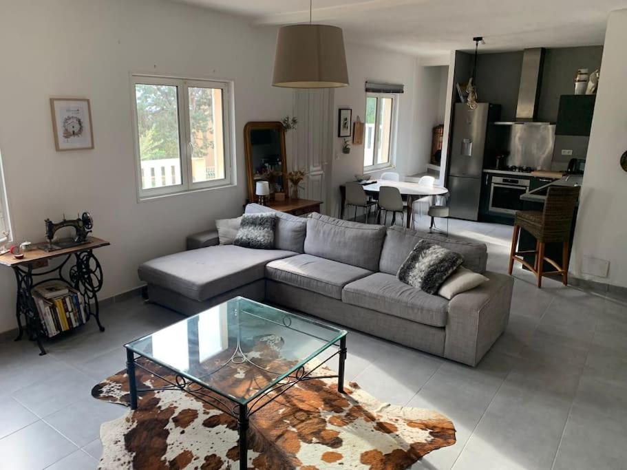 sala de estar con sofá y mesa de cristal en Jolie maison individuelle dans l’extrême sud, en Monacia-d'Aullène