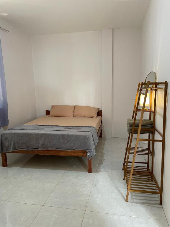 um quarto com uma cama e uma escada em Buhay Probinsya - Bubolongan em El Nido